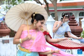 Tourists in Thai traditional costumes pose for photos at the Wat Arun in Bangkok, Thailand, October 9, 2025. (Photo: Xinhua) 