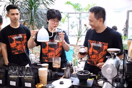 A barista demonstrates coffee brewing for visitors at the event. (Photo: VNA)