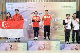 Gold medallists Le Thi Mong Tuyen and Nguyen Thanh Nam celebrate on the podium. (Photo: qdnd.vn)