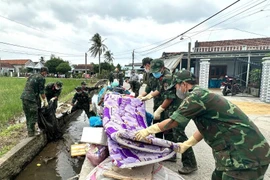 Soldiers help flood-hit communities clean up in Hoa Thinh commune, Dak Lak province. (Photo: VNA)