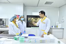 Dr. Vo Sy Nam (right) discusses genome sequencing technology with his colleagues. (Photo: VGP)