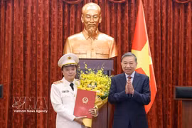 Party General Secretary and State President To Lam (R) presents the decision promoting Deputy Minister of Public Security Dang Hong Duc from the rank of Lieutenant General to Senior Lieutenant General. (Photo: VNA)