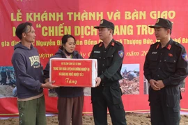 Lieutenant Colonel Pham Hong Phuc (right) from Mobile Police Command congratulates a couples in Thuong Duc commune, Da Nang city, on their new house built by the police force. (Photo: VNA)