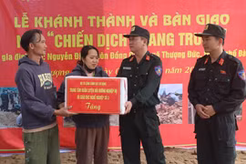 Lieutenant Colonel Pham Hong Phuc (right) from Mobile Police Command congratulates a couples in Thuong Duc commune, Da Nang city, on their new house built by the police force. (Photo: VNA)
