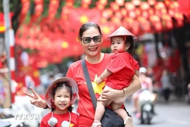 Many people capture moments with the national flag on Hang Ma street, Hanoi. (Photo: VNA)
