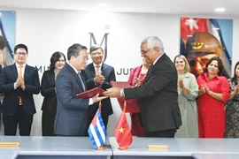 Visiting Vietnamese Minister of Justice Nguyen Hai Ninh (L) and his Cuban counterpart Oscar Manuel Silvera Martínez exchange documents after signing an agreement on a technical assistance project for the Cuban Ministry of Justice. (Photo: VNA)