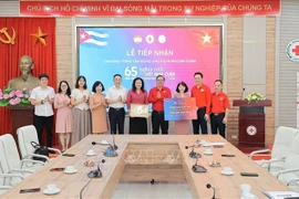 Deputy General Director of the Vietnam News Aagency Nguyen Thi Su (fifth, from right) presents donations to the Cuban people to the Vietnam Red Cross Society. (Photo: VNA)