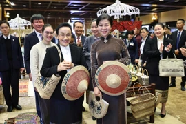 Ngo Phuong Ly (R), spouse of the Vietnamese Party General Secretary, and visiting Naly Sisoulith, spouse of the Lao Party General Secretary and President, take part in an exchange with outstanding artisans from several traditional craft villages of Ninh Binh province on January 27. (Photo: VNA)