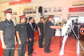Representatives of the armed forces of southern Lao provinces offer flowers at the ceremony. (Photo: VNA)