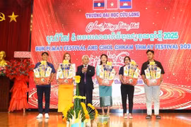 A representative of Cuu Long University presents gifts to Cambodian and Lao students. (Photo: VNA)