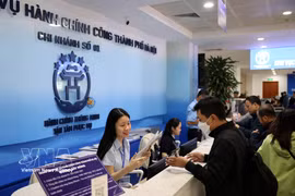 Civil servants at the Hanoi Public Administrative Service Centre assist residents with administrative procedures. (Photo: VNA)