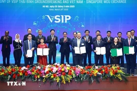 Prime Minister Pham Minh Chinh and his Singaporean counterpart Lawrence Wong witness the exchange of cooperative documents between Vietnamese and Singaporean enterprises in Hanoi on March 26. (Photo: VNA)