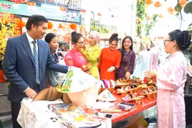 Vietnamese Ambassador to Malaysia Dinh Ngoc Linh (L) visits a booth at the event (Phôt: VNA)