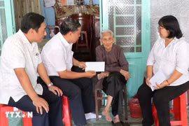 Leaders of the Party Committee, People's Council, People's Committee, and Vietnam Fatherland Front Committee of Phu Loi ward, Ho Chi Minh City, present gift from the Party and State to a social assistance recipient at her home on the occasion of the 14th National Party Congress and the 2026 Lunar New Year. (Photo: VNA)