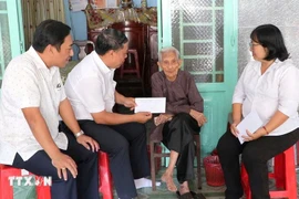 Leaders of the Party Committee, People's Council, People's Committee, and Vietnam Fatherland Front Committee of Phu Loi ward, Ho Chi Minh City, present gift from the Party and State to a social assistance recipient at her home on the occasion of the 14th National Party Congress and the 2026 Lunar New Year. (Photo: VNA)