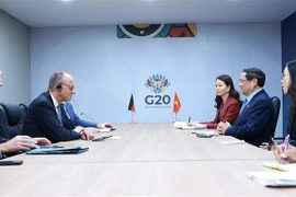Vietnamese Prime Minister Pham Minh Chinh (second, right) and German Chancellor Friedrich Merz (second, left) at their meeting in Johannesburg on November 23. (Photo: VNA)
