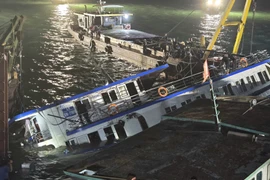 The capsized tourist boat in Quang Ninh is towed ashore. (Photo: VNA)