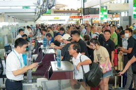 Passengers handle boarding procedures at Noi Bai International Airport (Photo: VietnamPlus)