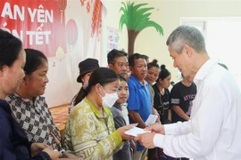 Vietnamese Ambassador to Cambodia Nguyen Minh Vu presents gifts to Vietnamese-oigin people in Cambodia (Photo: VNA)