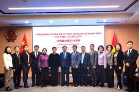 Participants pose for a group photo at the ceremony to mark the 76th founding anniversary of the diplomatic relations between Vietnam and China in Chongqing. (Photo: VNA)