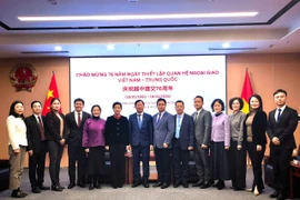 Participants pose for a group photo at the ceremony to mark the 76th founding anniversary of the diplomatic relations between Vietnam and China in Chongqing. (Photo: VNA)