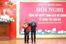 Le Minh Hung (R), Politburo member, Secretary of the Party Central Committee and Chairman of its Organisation Commission, hands over the appointment decision and congratulation flowers to Ho Van Nien, the new Secretary of the Quang Ngai Party Committee (Photo: VNA)