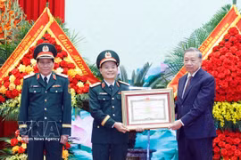 Party General Secretary and State President To Lam (right), who is also Secretary of the Central Military Commission, presents the "Hero of the People’s Armed Forces" title to representatives of Military Region 3 on April 10. (Photo: VNA) 