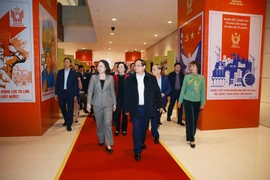 Prime Minister Pham Minh Chinh inspects the photo exhibition on the patriotic emulation movement throughout different periods, organised by the Vietnam News Agency. (Photo: VNA)