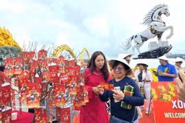 International tourists presented with New Year lucky money. (Photo: VNA)