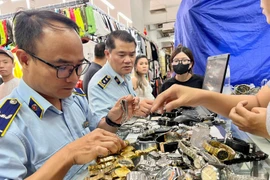 Officials from the Domestic Market Management and Development Department under the Ministry of Industry and Trade conduct direct inspections of “hotspots” for smuggling and counterfeit goods. (Photo: VietnamPlus)