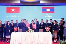 Minister of Industry and Trade Nguyen Hong Dien and his Lao counterpart Malaithong Kommasith sign the Vietnam - Laos Trade Agreement on April 8, 2024. (Photo: VNA)