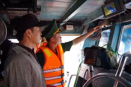 A Dong Thap border guard officer checks VMS device aboard a fishing a vessel (Photo: VNA)