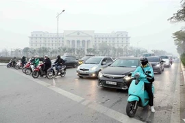 People comply with traffic signals at an intersection in Hanoi. (Photo: VNA)