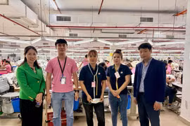 Le Ngoc Toan, First Secretary and Head of the Labour Management and Expert Committee in Malaysia (first, right) and First Secretary Thai Thi Huong (first, left) take a photo with Vietnamese workers at Ramatex Textiles factory in Johor. (Photo: VNA)