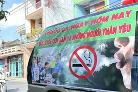 A banner on the side of a car urges people to quit smoking for their own health and that of their loved ones (Photo: VNA)