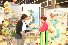 A foreigner learns about Vietnamese culture at the 35th Hong Kong book fair. (Photo: VNA)