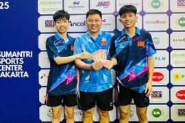 Vietnamese pair Nguyen Van Tuan Anh and Nguyen Duc Viet receive a bonus payment from their coach after winning. (Photo of VTTF)