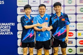 Vietnamese pair Nguyen Van Tuan Anh and Nguyen Duc Viet receive a bonus payment from their coach after winning. (Photo of VTTF)