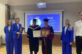 Professor Dr. Tran Hong Thai receives the honorary doctorate title and certificate from Professor Nikolay Rogalev of MPEI. (Photo published by VNA)