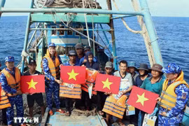 National flags and life jackets are presented to fishermen. (Photo: VNA)