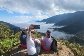 Tourists experience the Divine Rock tour in La Pan Tan commune, Mu Cang Chai district, Yen Bai province. (Photo: VNA)