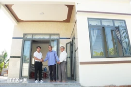 A revolution contributor is happy to get a new home built under the housing support programme. (Photo: VNA)