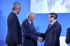Prime Minister Pham Minh Chinh (R) shakes hands with Iraqi President Abdul Latif Rashid at the Deltas of the World Summit in Nice, France, on June 9. (Photo: VNA)