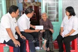 Representatives of the Party Committee, People's Council, People's Committee, and Vietnam Fatherland Front Committee of Phu Loi Ward in Ho Chi Minh City present gifts from the Party and State to a beneficiary at her home on the occasion of the 2026 New Year. (Photo: VNA)