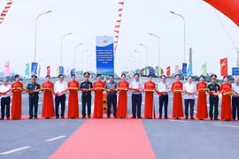 Prime Minister Pham Minh Chinh and delegates perform the ribbon-cutting ceremony to inaugurate the new Phong Chau bridge on National Highway 32C. (Photo: VNA)