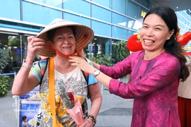 A representative of Anex Tour Vietnam presents a conical hat to the first passengers arriving in Da Nang from Vladivostok. (Photo: VNA)
