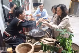 Visitors experience traditional coffee roasting by the Ede ethnic community. (Photo: nhandan.vn)