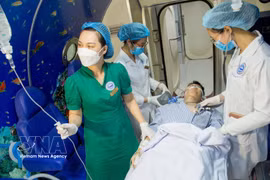Medical workers of the Vietnam National Institute of Maritime Medicine gives treatment to a patient using hyperbaric oxygen therapy. (Photo: VNA)
