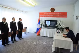 Ambassador Phan Manh Dung, who led a delegation from the Permanent Mission of Vietnam in Geneva, writes on the condolence book in commemoration of former Chairman of the Lao People's Revolutionary Party (LPRP) Central Committee, former President and former Prime Minister of Laos Khamtay Siphandone. (Photo: VNA)