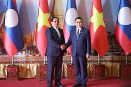 PM Pham Minh Chinh (L) and President of the Lao National Assembly Saysomphone Phomvihane (Photo: VNA)